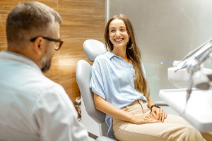Happy patient and dentist discussing dental implant treatment