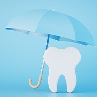 Tooth model underneath a blue umbrella