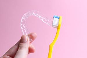 Toothbrush next to clear aligner