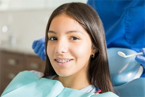Smiling teen girl with braces attending dental appointment