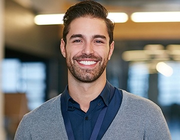 Smiling man wearing gray cardigan