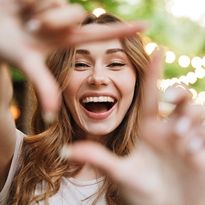 Framing smile with hands to show off dental bridge in Northborough