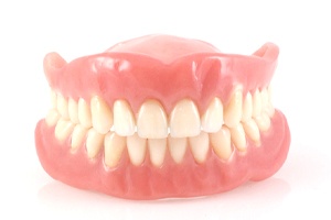 Full upper and lower dentures against white background