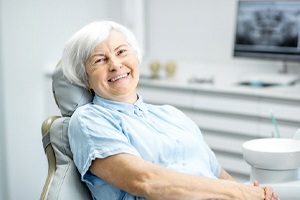 Female senior patient with dentures smiling at camera