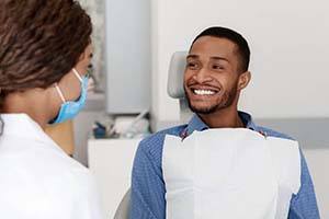 Man smiles at his Northborough emergency dentist after treatment