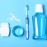 Tools for oral hygiene lined up against blue background