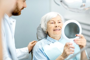 Older woman happy she qualified for implant dentures