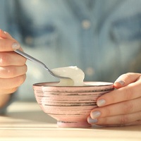 Woman eating yogurt as part of a no-chew diet
