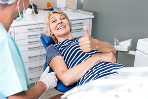 Relaxed patient giving thumbs up for dental implant surgery