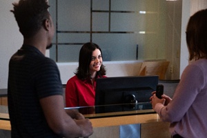 Patients at dental office front desk, paying for Invisalign