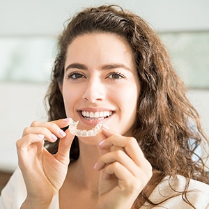 Woman placing Invisalign tray