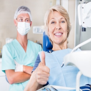 Happy dental patient making thumbs-up gesture