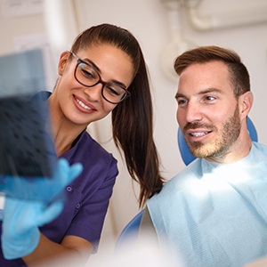 Man looking at dental x-rays during root canal therapy visit