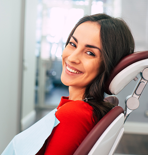 Woman smiling while sitting in dental chair