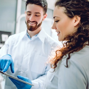 Happy patient and dentist discussing smile makeover plan