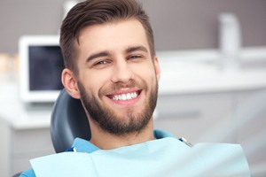 Male dental patient smiling after receiving tooth-colored fillings