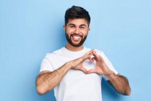 Man without gum disease making heart shape with hands