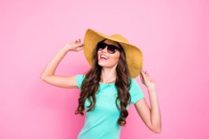 Smiling woman wearing sunhat and sunglasses