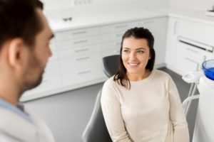 Happy dental patient talking to dentist