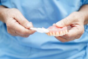 Dentist demonstrating how to clean dentures