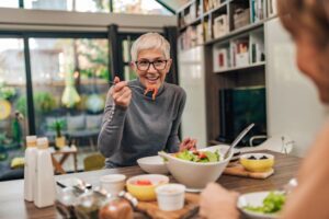 Senior woman eating a meal with a friend