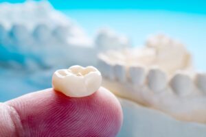 Dental crown resting on person's finger
