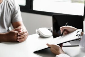 Patient and medical professional sitting at desk, talking 