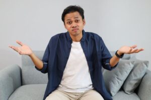 Man shrugging, wearing confused expression 